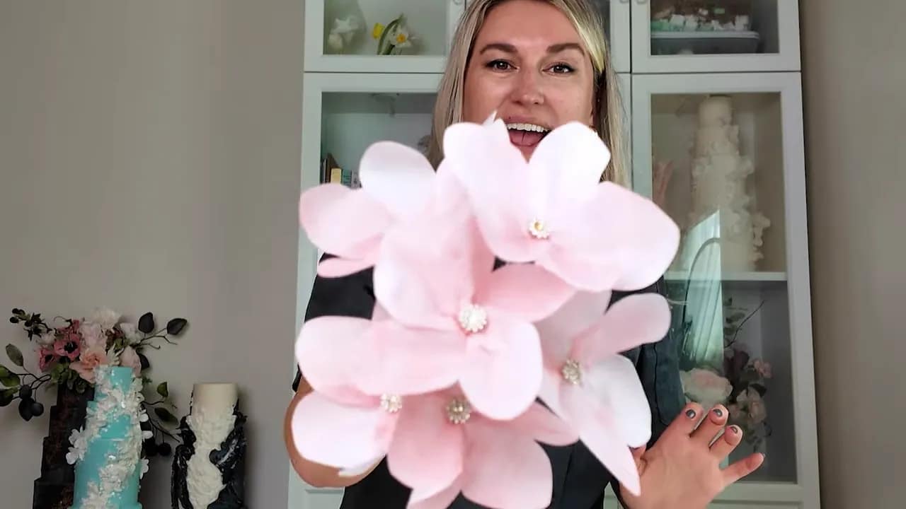 Pink wafer paper wedding cake flower with sparkling center held in hand