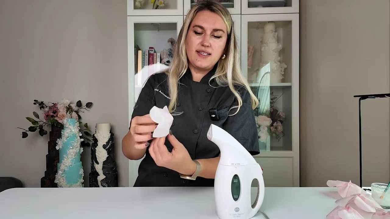 Wedding cake designer assembling wafer paper flower petals at the table